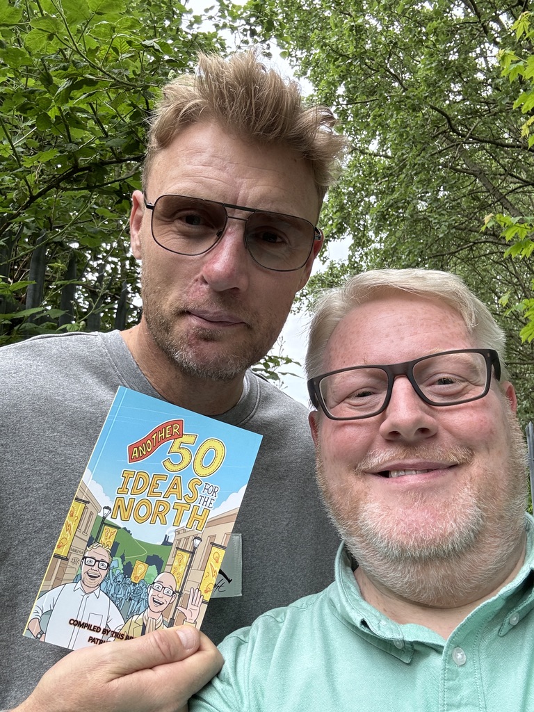 Tris Brown and Freddie Flintoff smile into the camera with a copy of Another 50 Ideas for the North